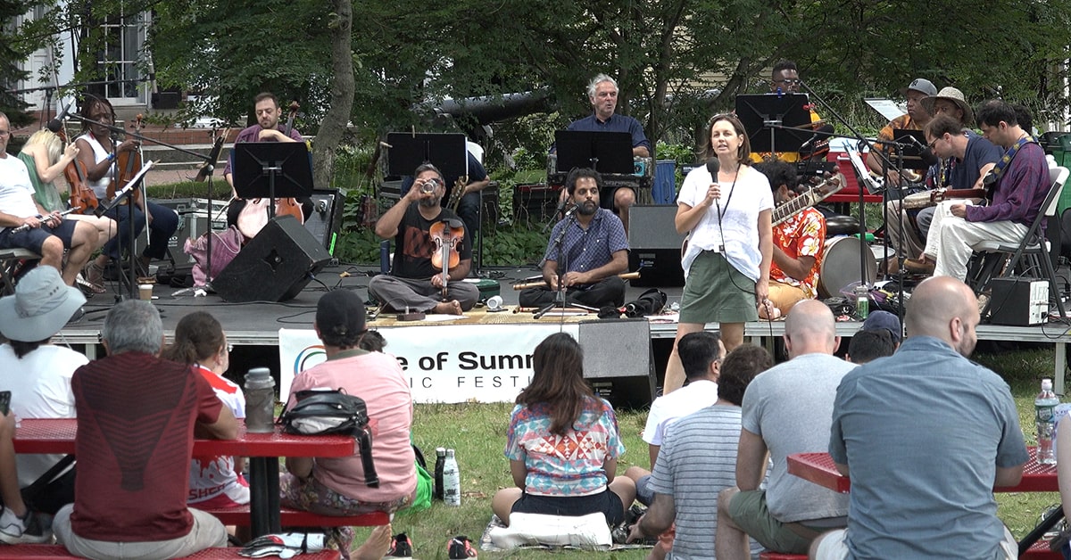 Pam speaks to the audience before the Brooklyn Raga Massive performance